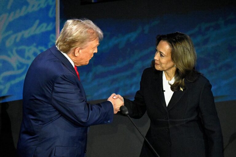 Donald Trump and Kamala Harris shaking hands on stage during a U.S. presidential debate.