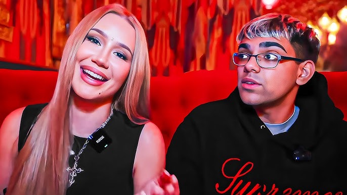 Iggy Azalea smiling beside streamer N3on during a red-lit interview setting.