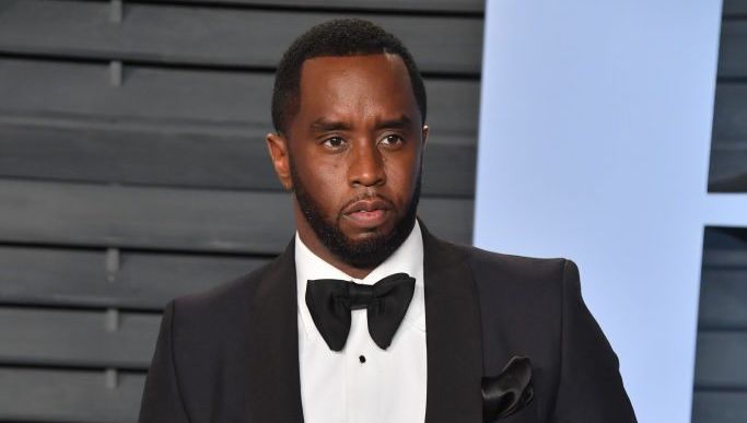 Diddy wearing a black tuxedo and bow tie while attending the Vanity Fair Oscar Party red carpet event.
