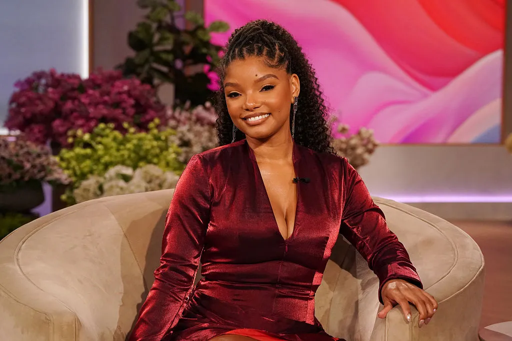 Halle Bailey sitting on couch