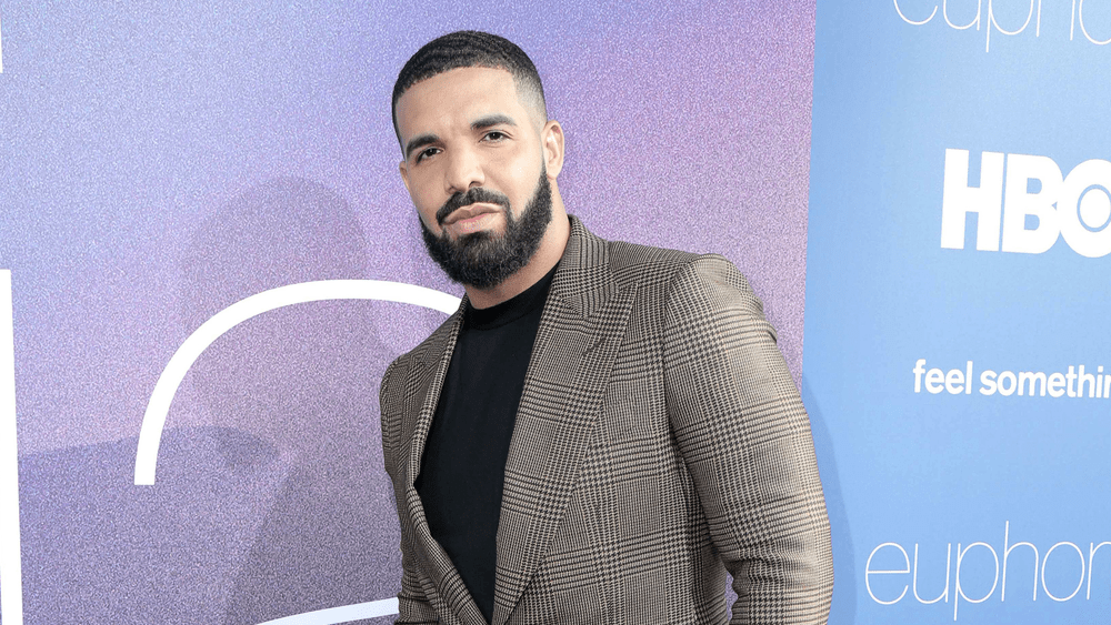 Man posing on purple backdrop.
