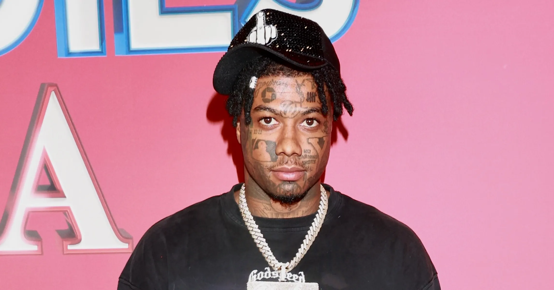 Rapper standing on pink drop smiling slightly